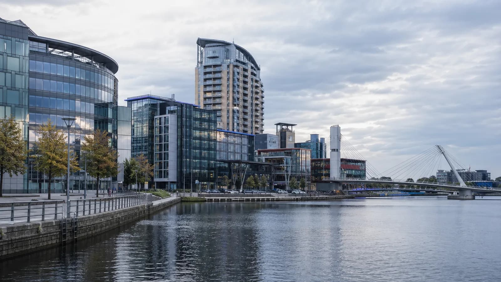 Salford Quays-style waterfront and modern media district architecture on an overcast UK afternoon.